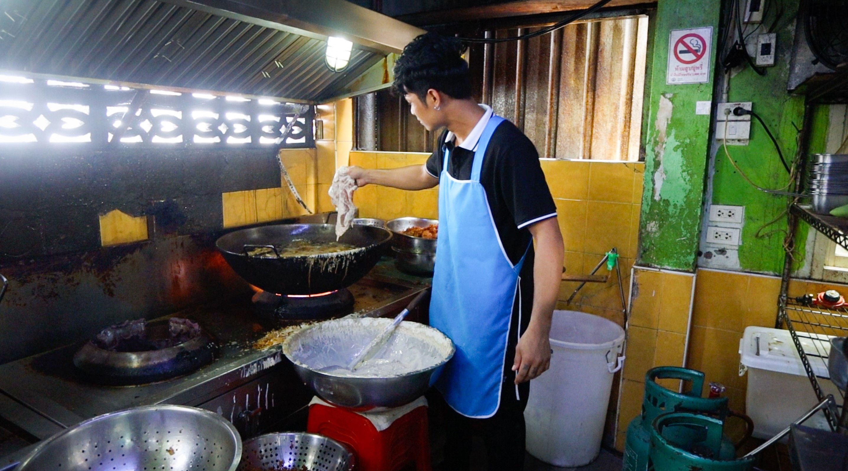 A Man Frying Thin Pork Cutlets In The Kitchen